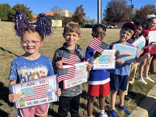 students with flags and thank you posters